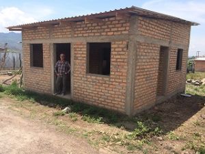 Mateo in doorway of nearly completed house #8 Edit